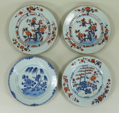 quatre assiettes ornées de motifs bleus et orange, posées sur une table