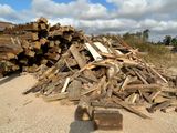 a pile of wood sitting on the ground next to a pile of logs
