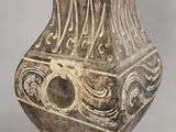 an old vase with a design on it sitting on a table