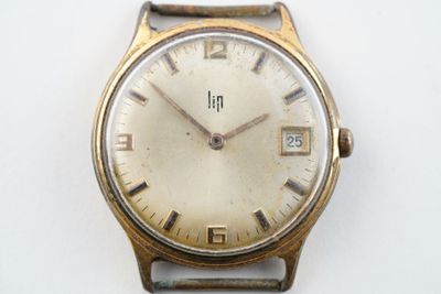 une montre posée sur une surface blanche