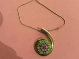 un gros plan d'un collier orné d'une fleur, posé sur un fond rose