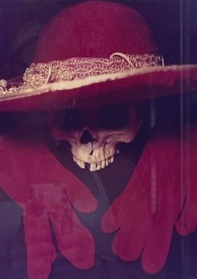 a skull wearing a red hat and red gloves