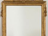 une image d'un miroir encadré d'or sur un mur blanc