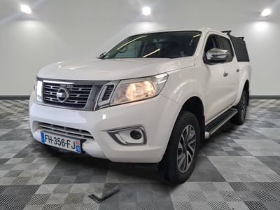 La Nissan Frontier blanche est garée dans une grande pièce.