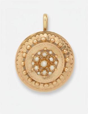 un gros plan d'un pendentif en or orné de perles sur fond blanc