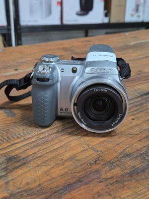 a silver camera sitting on a wooden table