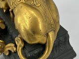 an image of a golden lion statue on a black base