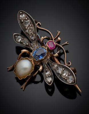 un gros plan d'une broche ornée d'une perle et d'une libellule