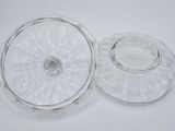 two clear glass dishes with lids on a white surface