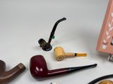 many different types of smoking pipes on the table