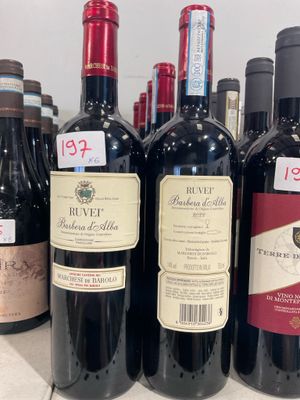 plusieurs bouteilles de vin rouge sont alignées sur un comptoir