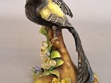 un oiseau jaune et noir perché sur une branche d'arbre ornée de fleurs
