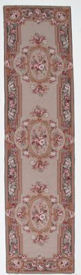 tapis beige et rouge orné de médaillons et de fleurs sur fond blanc