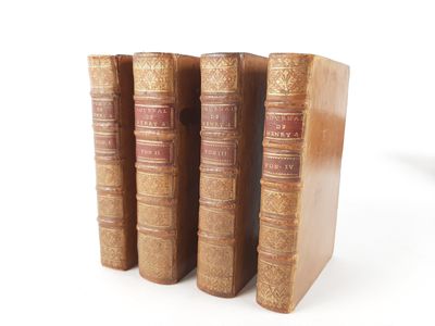 three old books sitting on top of each other on a white surface