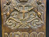 une vieille enseigne en métal sur laquelle figurent un lion et une couronne