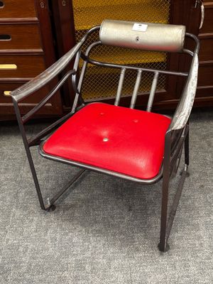une chaise en métal avec une assise rouge dans une pièce