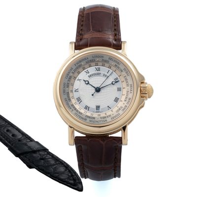 une montre et un stylo posés l'un à côté de l'autre