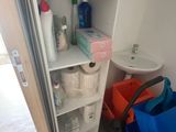 une salle de bains équipée de toilettes, d'un lavabo et d'une étagère