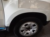 a white truck with a flat tire on the side of the road