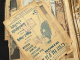 a pile of old newspapers and a pair of scissors on a table