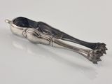 an antique silverware spoon and tonget on a white surface
