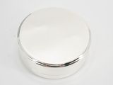 an image of a round silver box on a white surface