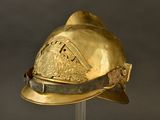 a gold helmet that is on display on a stand