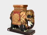 un éléphant en bois orné d'un motif rouge et doré sur le dos