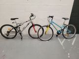 two bikes parked next to each other in a parking lot