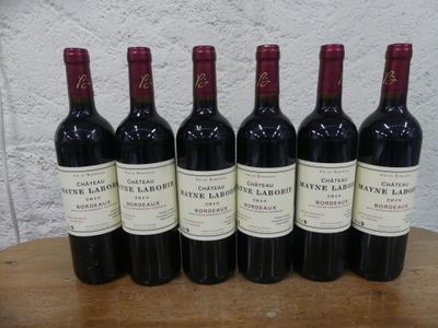 six bouteilles de vin rouge sont alignées sur une table