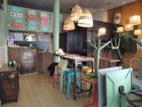 brightly colored chairs and tables in a restaurant with a menu on the wall