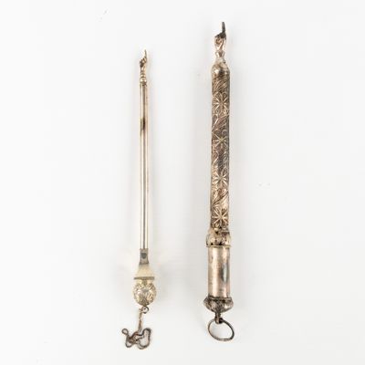 a pair of silver colored metal objects on a white surface