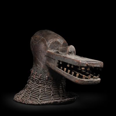 une image d'un masque en bois sur fond noir