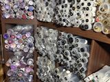 many rolls of fabric on the shelves of a craft store