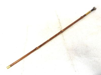 a close up of a stick with a wooden handle on a white surface