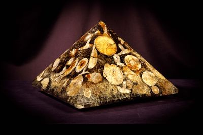 a picture of a pyramid made of rocks with a clock on it