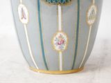 a blue vase with gold trimmings and a clock on it
