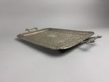 a silver tray with handles and handles on a white surface