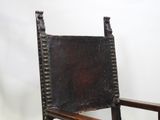 a wooden chair that has a leather seat on top of it