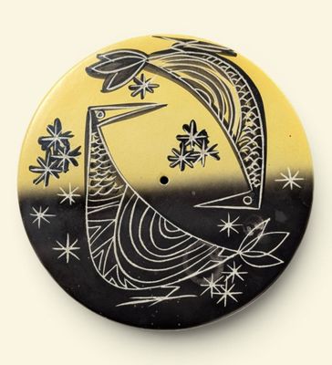 a black and yellow button with a bird on it