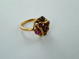 a close up of a gold ring with pink stones on it