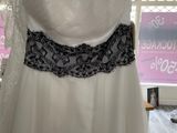 wedding dress hanging on a hanger in front of a window
