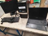 a laptop computer sitting on a desk next to a monitor and keyboard