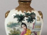 a small vase with a painting on it sitting on a table