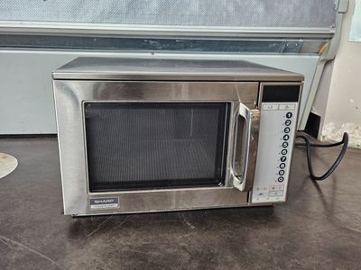 a microwave that is sitting on the floor next to a wall