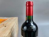 a bottle of wine sitting on a table next to a wooden box