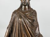 a bronze statue of a woman holding a book and a book