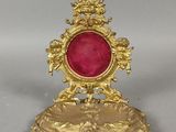 une image représentant une horloge dorée et rouge posée sur une table