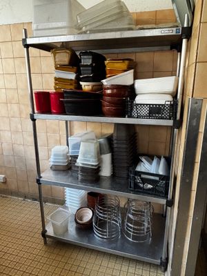 a metal shelf with dishes on it in a kitchen