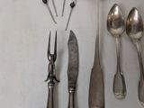 a lot of silver spoons and spoon knives on the table
